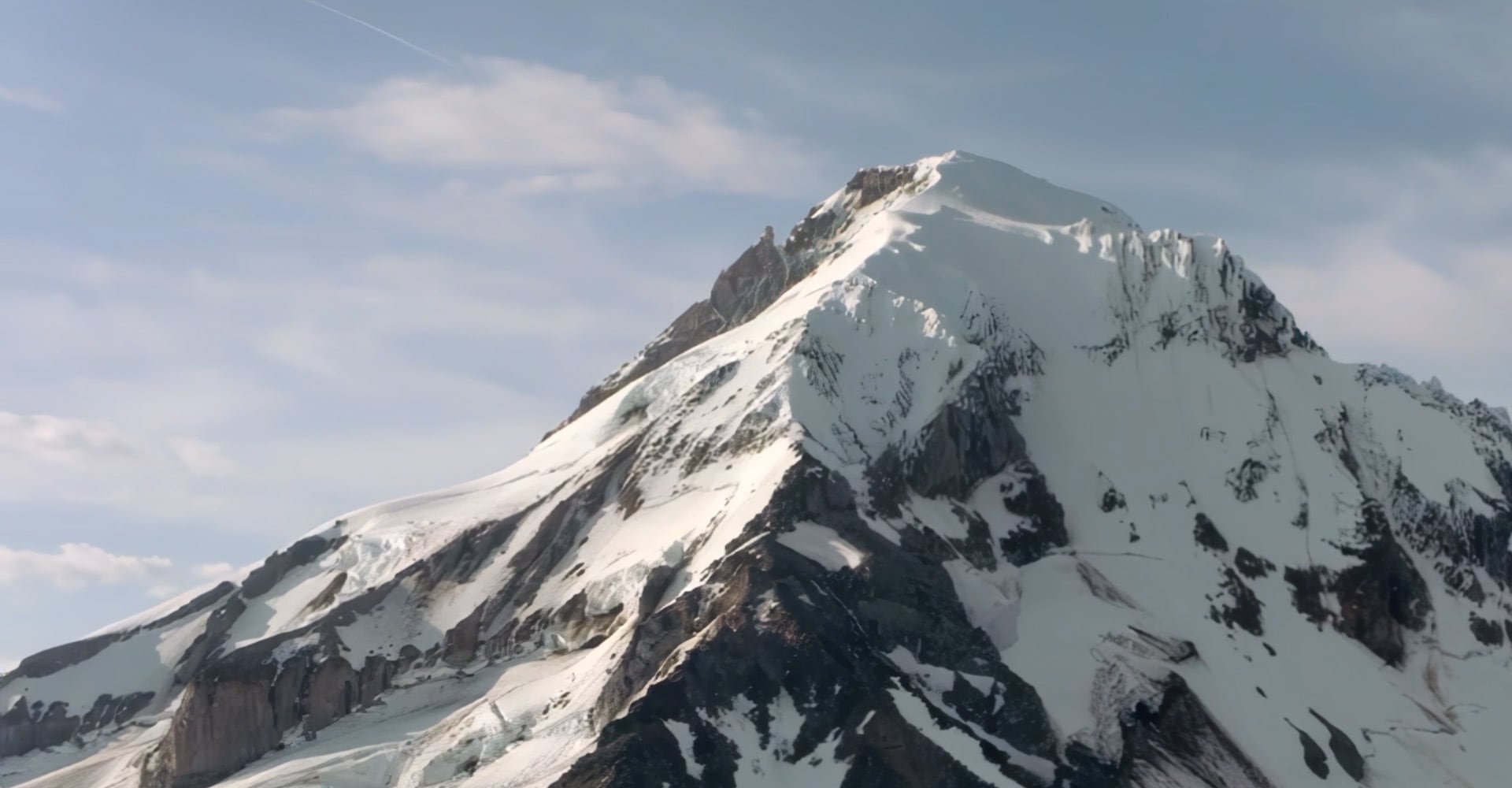 A snowy mountain peak is seen from a distance.