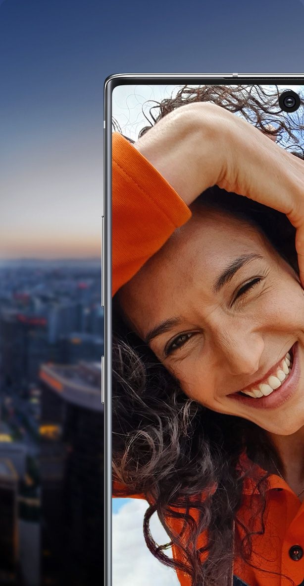 Galaxy Note10 plus split in half with a woman smiling onscreen. One half is shown against a night sky and the other half is shown against a daytime sky, demonstrating that the cinema-grade HDR10 plus display shows true colors, day or night