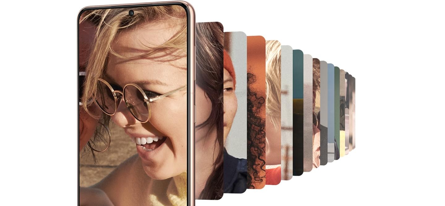 Galaxy S21 Plus 5G seen from the front with an image of a woman laughing onscreen. A gallery of images is seen behind it.