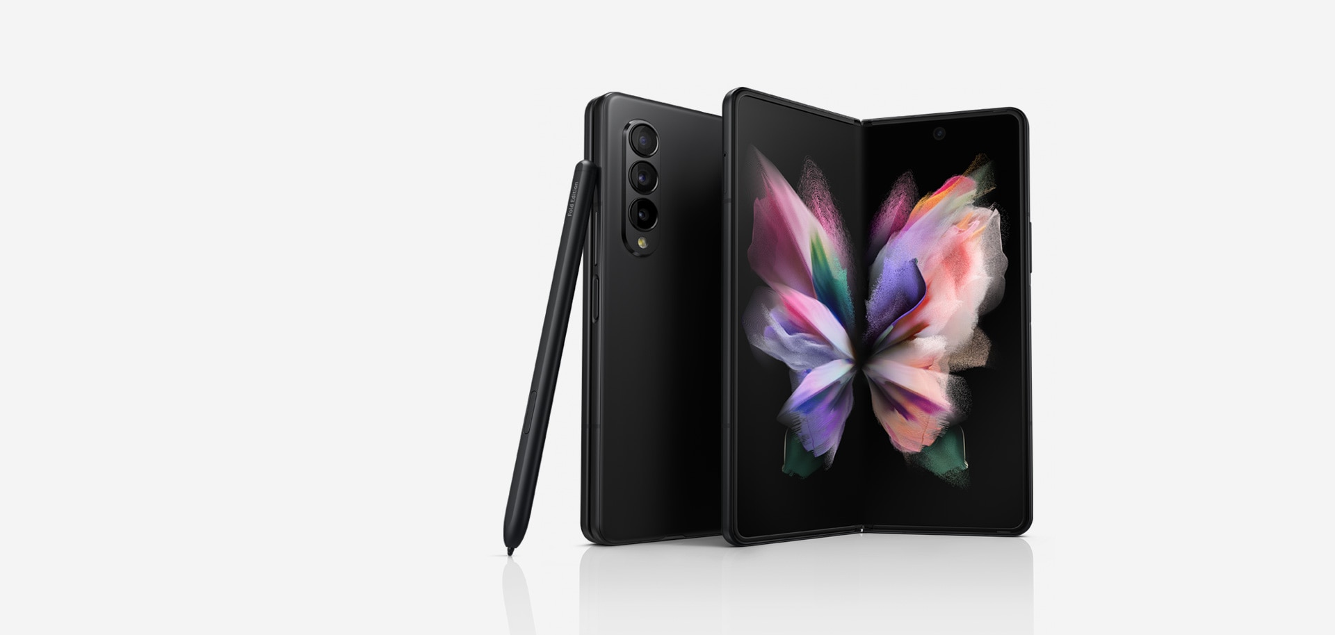 Two Galaxy Z Fold3 5G phones, one seen folded from the Back Cover and one seen unfolded with a colorful wallpaper on the Main Screen. The S Pen Fold Edition leans against the folded phone.