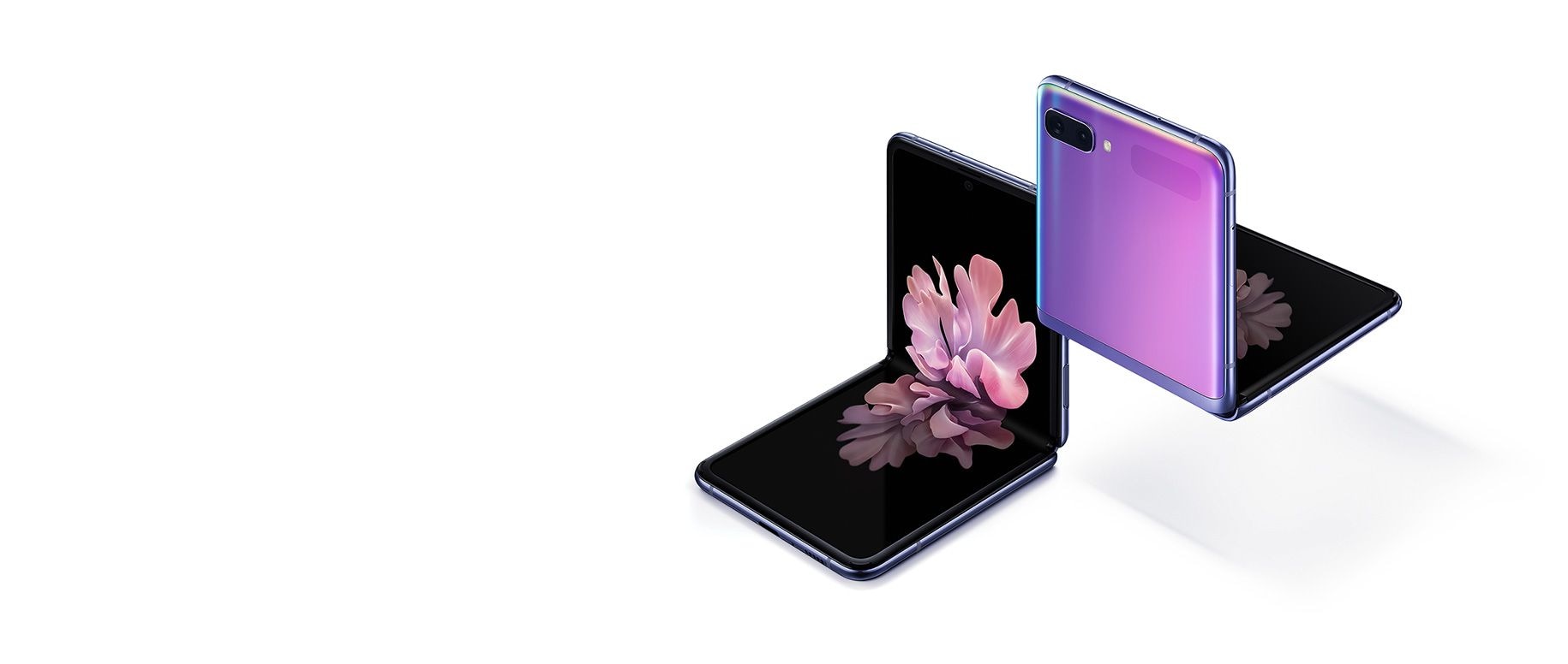 Două telefoane Galaxy Z Flip de culoare violet lucioasă, la un unghi 3/4, unul văzut din față, celălalt văzut din spate. Ambele sunt pliate la unghi drept, blocate cu suport. Cel văzut din față are pe ecran o imagine de fundal cu o floare înflorind