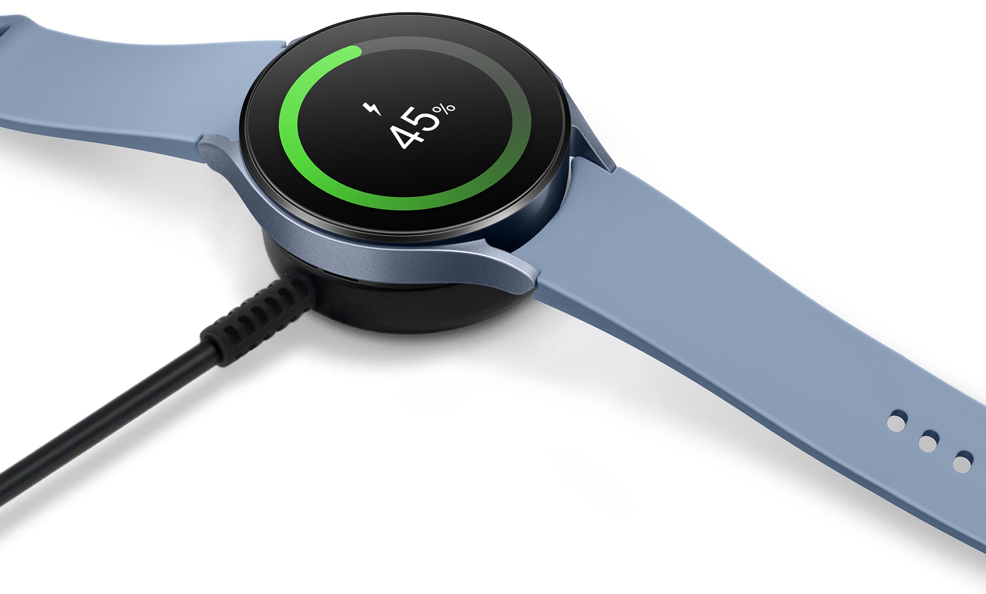 A Sapphire Galaxy Watch5 on top of a wireless charger in black.