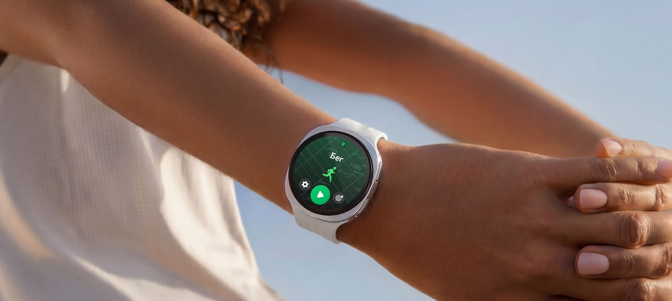 Человек в Galaxy Watch9 цвета серебро со спортивным ремешком цвета латте выполняет упражнения на растяжку. На экране устройства открыта программа тренировки по бегу.