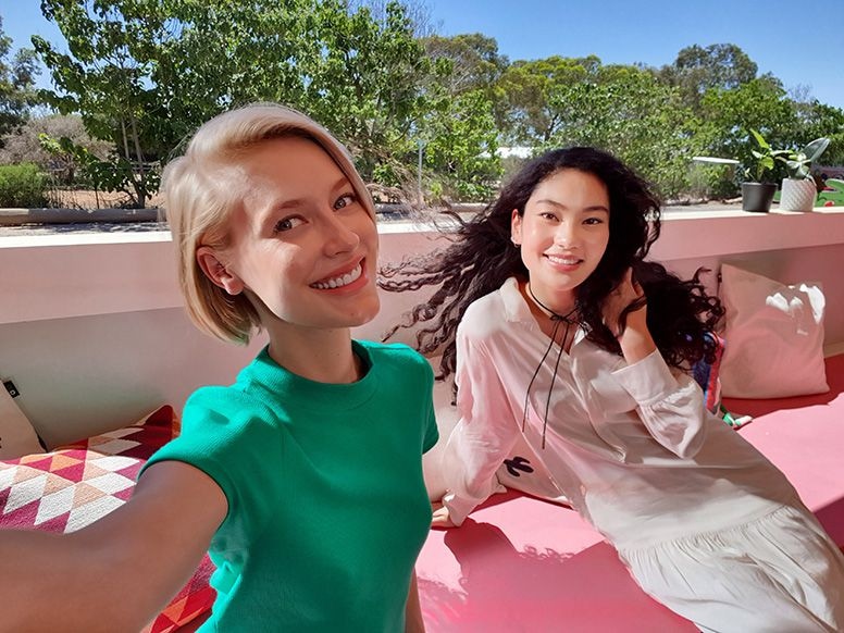 Selfie taken on Galaxy S10 plus of two women sitting in a shaded area but theyâre in-focus and clear because of the Dual Pixel Sensor.