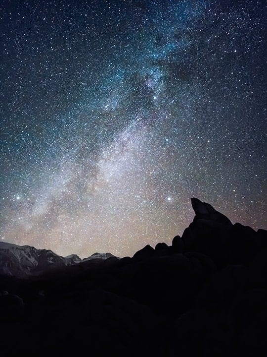 Ночная пейзажная фотография с силуэтом горной местности на переднем плане. Детали звездного неба четко переданы в высоком разрешении с помощью функции Expert Raw. Фотография была сделана на камеру Galaxy S23 Ultra с использованием ISO 1600, широкоугольного режима и диафрагмы F 1,7.