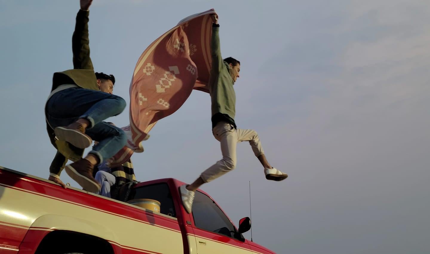 Three friends riding in a pick-up truck, with two jumping out of the back. Scene shot with 8K video mode, and one still cut captured with 8K Video Snap.