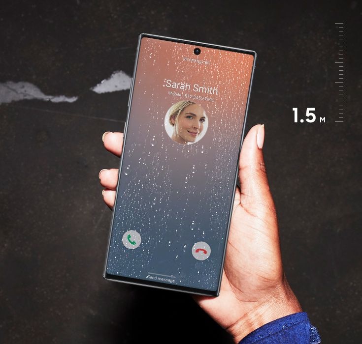 Hand holding Galaxy Note10+ outside with a bold image onscreen and water droplets on the screen, showing the water resistance of IP68