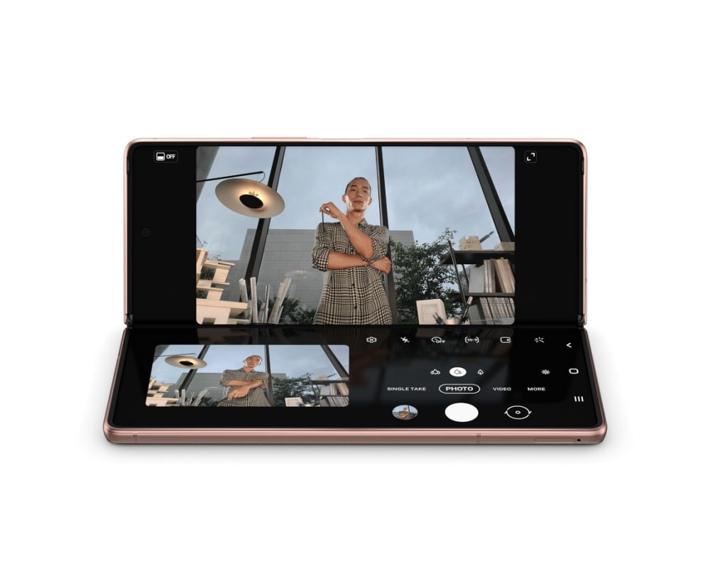 Mystic Bronze renkte Galaxy Z Fold2 Flex modda. Ekran, Kamera uygulamasına geçerek Yakalama Görünümü Modu ile eller serbest bir şekilde selfie çeken bir adamı göstererek ona az önce çektiği fotoğrafın daha büyük bir önizlemesini verir.