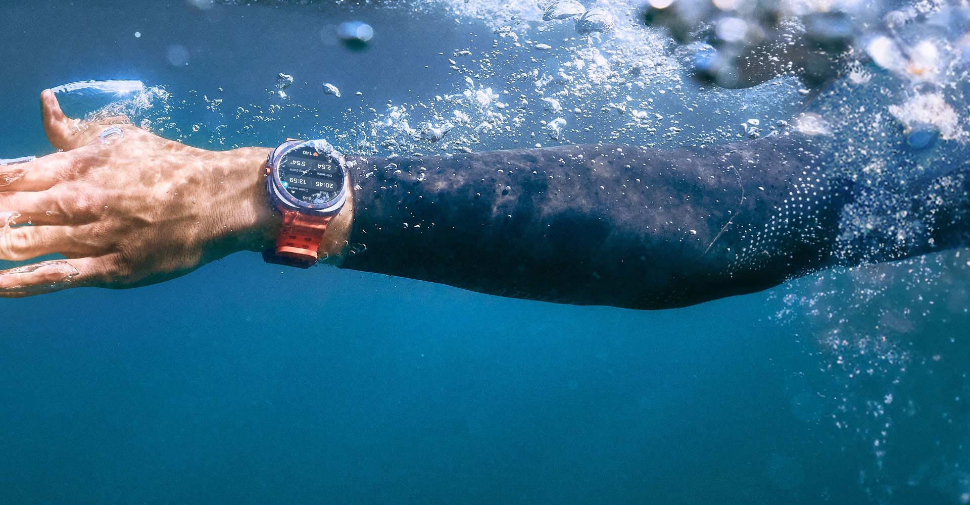 A hand in the water wearing a Galaxy Watch Ultra on the wrist.