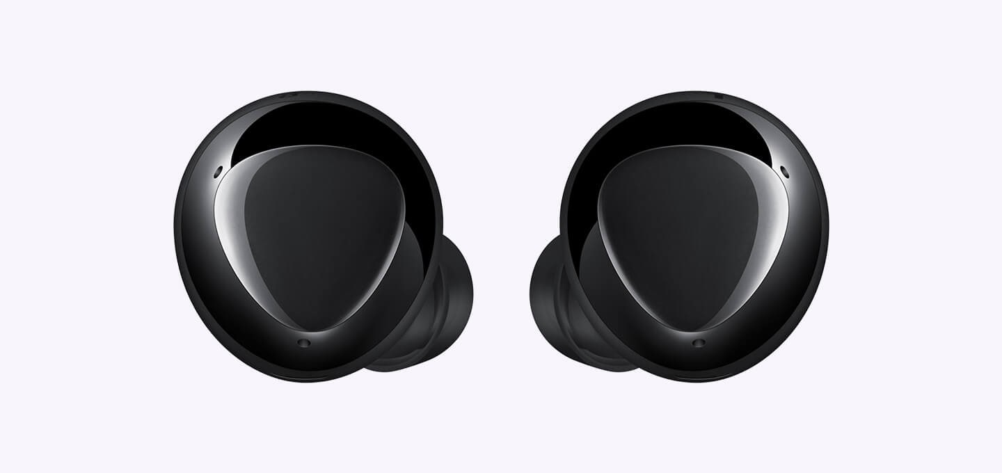 An enlarged pair of black earbuds displaying the triangular design on the outer surface.