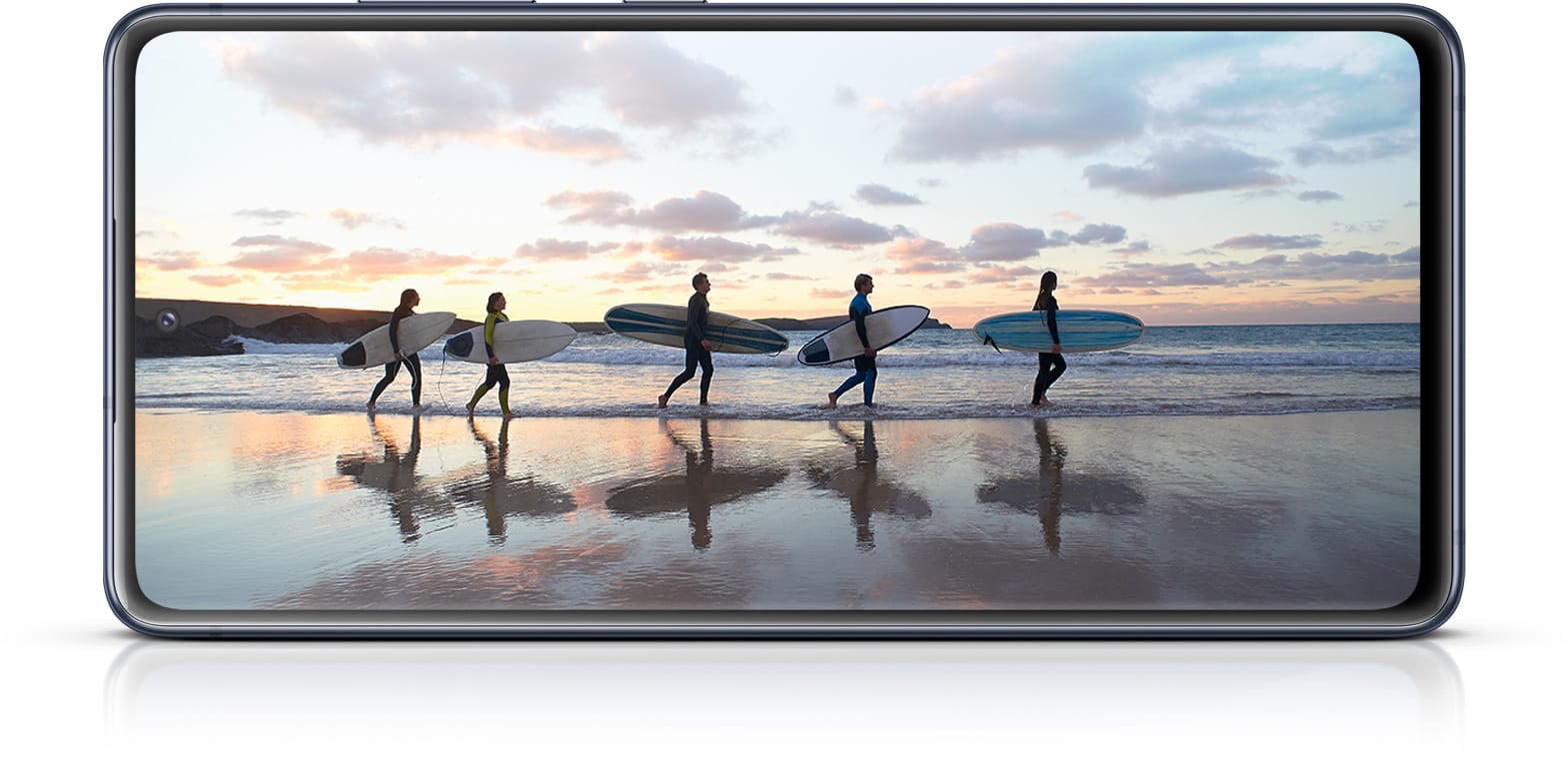 Galaxy S20 FE with a photo of surfers onscreen, showing the immersiveness of the Infinity-O Display.