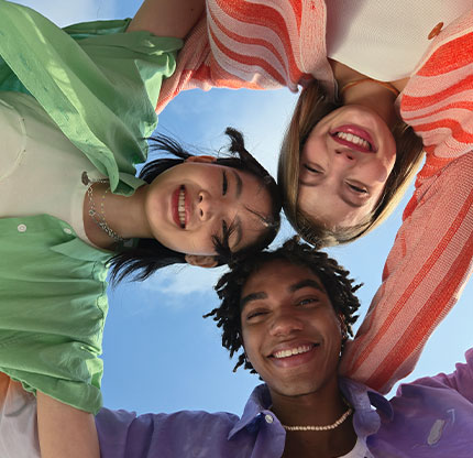 Three friends pose together for the selfie taken from above Galaxy Z Flip6 at a distance.