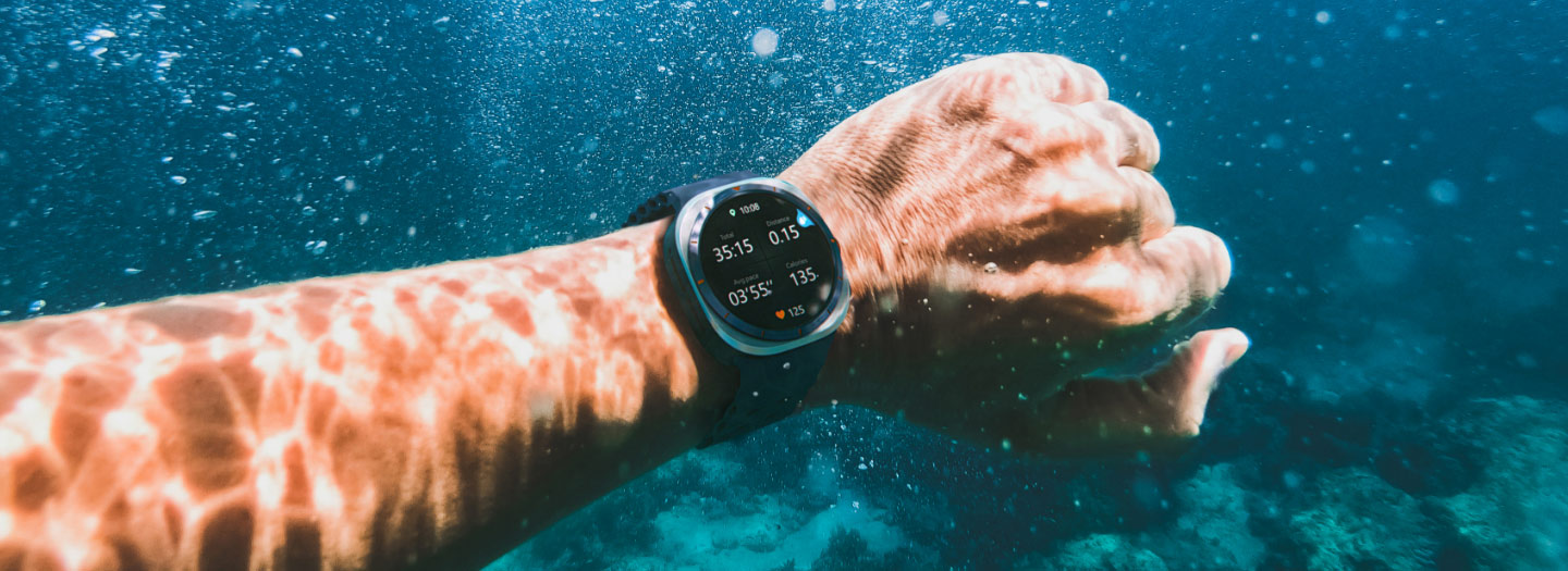 A hand in the water wearing a Galaxy Watch Ultra on the wrist.