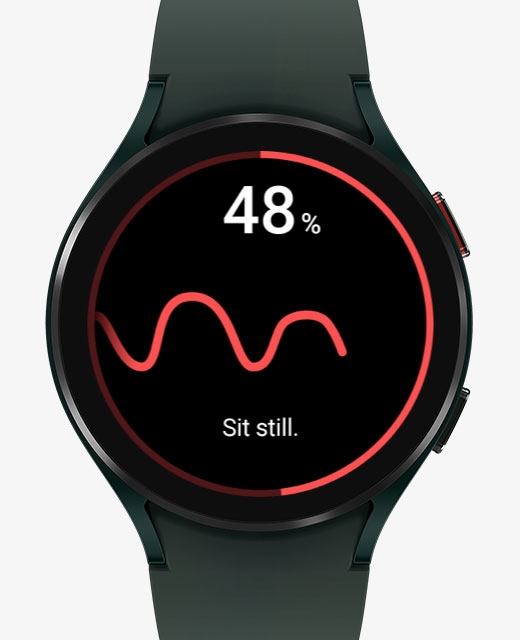 The front watch face of the Galaxy Watch4 device is measuring blood pressure. Its display changes from the blood pressure measuring feature to the ECG measuring feature.