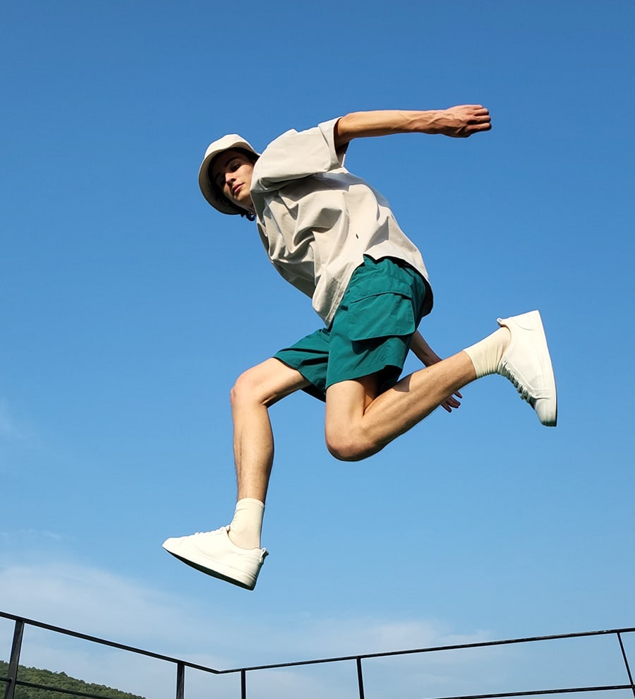 A man jumping and looking down into the camera.